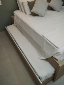 a close up of a bed with white sheets and pillows at Flat Amarilis Apartamento 202 in Riviera de São Lourenço