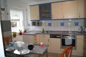 a kitchen with a table and a kitchen with blue cabinets at Has und Igel in Neubukow
