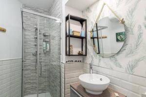 La salle de bains est pourvue d'une douche, d'un lavabo et d'un miroir. dans l'établissement El Sueño de Cádiz by Gades Gestión, à Cadix