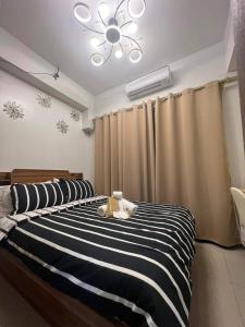 a bedroom with a black and white striped bed at Briannas Crib in Manila