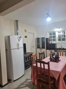una cucina con un tavolo e un frigorifero bianco di Casa aluguel temporada _Torres a Torres