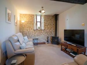 a living room with a couch and a flat screen tv at Pass the Keys Converted 17th century barn with garden parking in Cheltenham