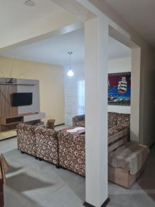un soggiorno con un divano e una televisione di Casa aluguel temporada _Torres a Torres