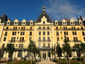 ein großes gelbes Gebäude mit schwarzem Dach in der Unterkunft Les Suites du Bernascon - Appartement 4 étoiles in Aix-les-Bains