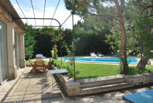 謝瓦布朗克的住宿－Mas provençal avec piscine，池畔露台配有桌椅