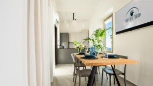 Un comedor y una cocina con mesa y sillas de madera. en APPARTAMENTO - Molo del Porto A, en Civitavecchia