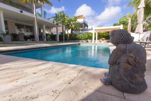 una estatua junto a una piscina en Goudhaen Luxury Private apartments Jan Thiel Beach, en Jan Thiel