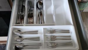 un cajón blanco lleno de utensilios de plata en Moderne Wohnung mit Gartenzugang, en Essen