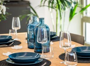 una mesa con copas de vino y botellas azules. en Molo del porto, en Civitavecchia