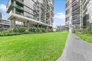 an apartment building with a green lawn in front of it at Family Residence (3 Bedrooms, Pool, Gym, Parking) in Sydney