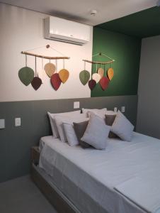 Flat Amarilis Apartamento 202 في ريفييرا دي ساو لورينسو: غرفة نوم بسرير كبير وبها وسائد واضاءات
