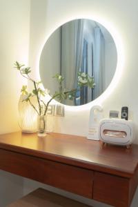 a mirror sitting on top of a wooden table with aounter sidx sidx at Ha Trang Voronezh Hotel and Apartment in Nha Trang