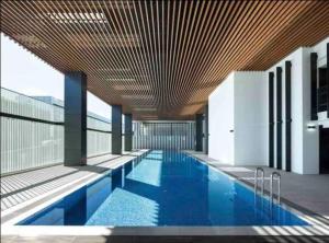a swimming pool in a building with a wooden ceiling at Family Residence (3 Bedrooms, Pool, Gym, Parking) in Sydney