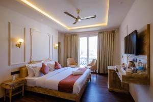 een hotelkamer met een groot bed en een bureau bij Infinia Stays - A Luxury Boutique Hotel in Udaipur