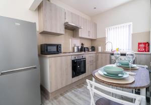 a kitchen with a table and a refrigerator at Free Parking | Free Wifi | Stylish in Newport