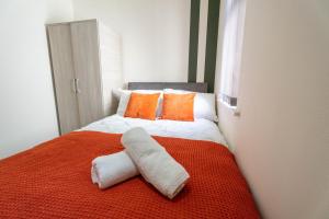 Un dormitorio con una cama con una toalla. en Cohost Partners | Free Parking | Free Wifi, en Newport