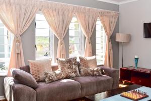 salon z kanapą i dużym oknem w obiekcie Villa Palesa Guesthouse w mieście Grahamstown