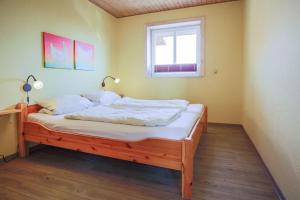 a bedroom with a wooden bed with a window at Buedlfarm-Haus in Sahrensdorf