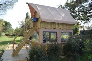 a tiny house with a roof on a deck at La Bivouac in Nort-sur-Erdre