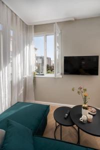 a living room with a blue couch and a table at NEW! High-street stylish flat (NDK) FREE Parking in Sofia