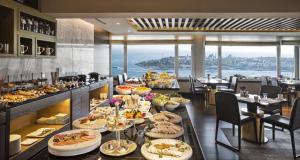 a buffet line with plates of food in a restaurant at The Marmara Taksim in Istanbul