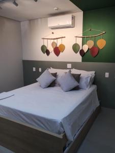 a bedroom with a large white bed with a green wall at Flat Amarilis Apartamento 202 in Riviera de São Lourenço