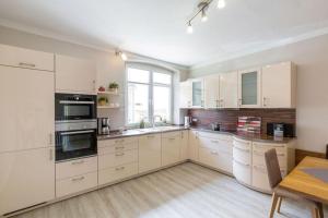 Sahrensdorf的住宿－Buedlfarm-Bauers-Haus，一间大厨房,配有白色的橱柜和一张桌子