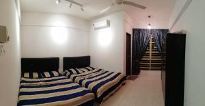 2 Betten in einem Zimmer mit einer Treppe in der Unterkunft Hafizah Homestay Bangi-Kajang in Kajang