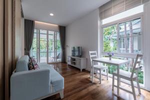 ein Wohnzimmer mit einem Sofa und einem Tisch in der Unterkunft Na Sook Wellness Resort in Ao Nam Mao