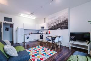 a living room with a couch and a table and a kitchen at Spacious City Centre Retreat in Leeds City Centre in Leeds