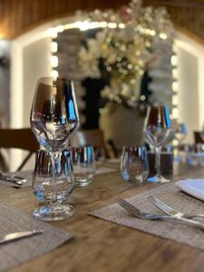 a table with wine glasses on a wooden table at Hôtel le Jalouvre in Mont-Saxonnex