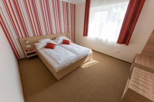 a bedroom with a bed and a window at Belvárosi Nemes Apartmanház Szekszárd in Szekszárd