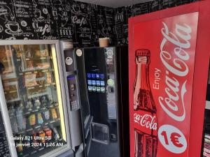 dos máquinas expendedoras de cocacola junto a una máquina de refrescos en Hôtel des allées, en Marsella