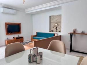 托澤爾的住宿－Dar Zakaria Toursitic Area，客厅配有桌椅和沙发
