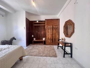 a bedroom with a bed and a wooden door and a table at Dar Zakaria Toursitic Area in Tozeur