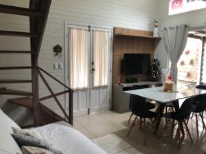 a room with a table and chairs and a desk at Casa para temporada in Florianópolis