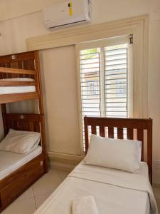 1 dormitorio con 2 literas y ventana en Pousada Casa Mucugê en Porto Seguro
