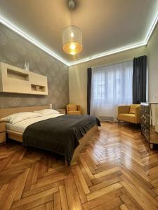 sypialnia z łóżkiem, krzesłem i oknem w obiekcie BpHomes w Budapeszcie