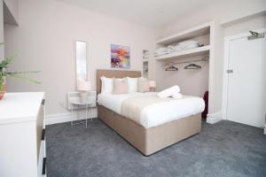 a white bedroom with a large bed and a desk at Archer Road Penarth Free parking in Cardiff