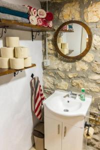 uma casa de banho com um lavatório e um espelho em Old House Piperi em Podgorica