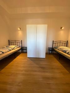 Habitación con 2 camas y puerta blanca en Pelster´s Apartments en Diepholz