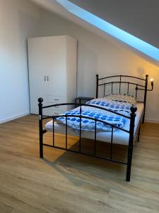 a bedroom with a bed with a black frame at Pelster´s Apartments in Diepholz