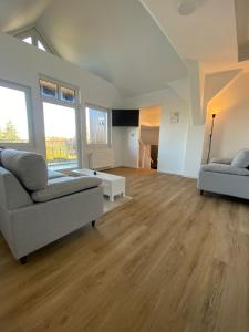 sala de estar con 2 sofás y suelo de madera en Pelster´s Apartments en Diepholz