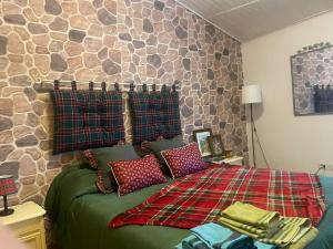 een slaapkamer met een bed met een stenen muur bij La casina in Voltaia in Piancastagnaio