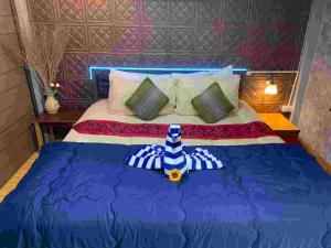 ein Schlafzimmer mit einem blauen Bett mit einer Blume darauf in der Unterkunft วังหินบังกะโล 