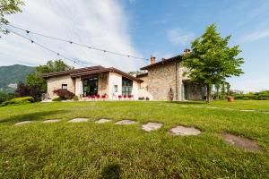 a house with a grass yard in front of it at Borgo Pianello Country Resort in Lizzano in Belvedere