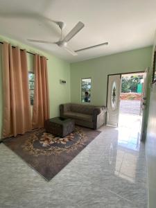 a living room with a couch and a ceiling fan at D'Batu Hampar Homestay R2 