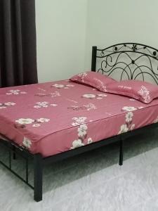 a bed with a pink blanket on top of it at D'Batu Hampar Homestay R2 