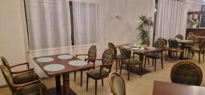 grupa stołów i krzeseł w pokoju w obiekcie BusinessHotel Mühlenbeck w mieście Mühlenbeck