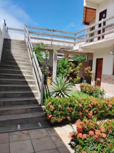 um conjunto de escadas que levam a uma casa com flores em Flat em Porto de Galinhas "com varanda" em Porto de Galinhas
